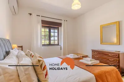 a bedroom with a bed and a dresser and a mirror at #240 Beach House - Casa da Balaia by Home Holidays in Olhos de Água