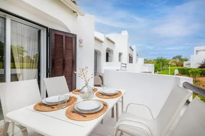 a white living room with a couch and a table at Clube Albufeira - 2BR Pool, Kids Club & Family Fun in Albufeira