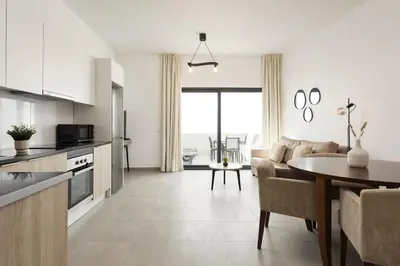 a kitchen and living room with a table and a couch at Castilhos 1 - City center by HD in Faro