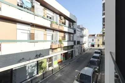 an apartment building with cars parked on a street at Castilhos 2 - City center by HD in Faro