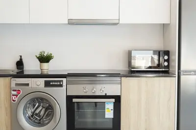 a kitchen with a washing machine and a microwave at Castilhos 2 - City center by HD in Faro