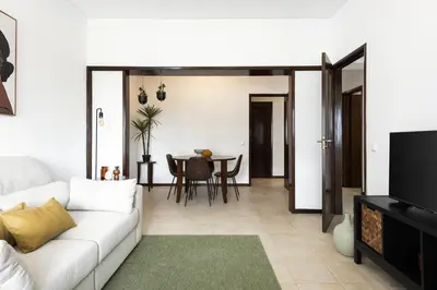 a living room with a white couch and a television at Salty - Near the city by HD in Faro
