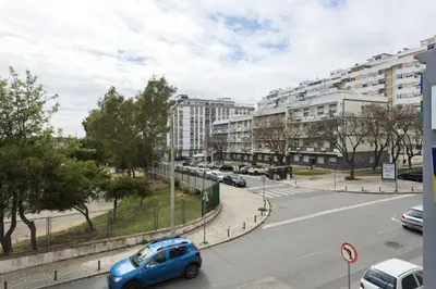 a blue car driving down a city street with buildings at Salty - Near the city by HD in Faro