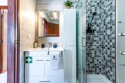 a bathroom with a sink and a shower at O Canto do Oceano T2 Albufeira in Albufeira