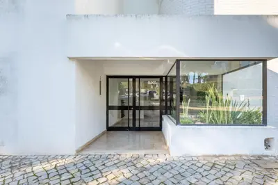 an open door to a white building with glass at 2 BDR Flat With Pool in Vilamoura by LovelyStay in Quarteira