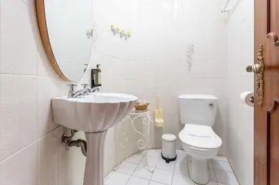 a white bathroom with a sink and a toilet at 2 BDR Flat With Pool in Vilamoura by LovelyStay in Quarteira