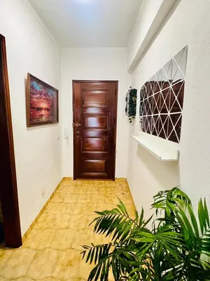 a hallway with a wooden door and a plant at Milennium Holiday Apartment in Quarteira