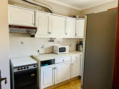 a kitchen with white cabinets and a microwave at Milennium Holiday Apartment in Quarteira