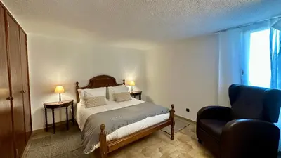 a bedroom with a bed and a blue chair at Gemini by Check-in Portugal in Albufeira