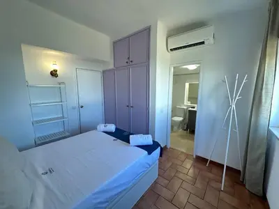 a small bedroom with a bed and a bathroom at White House By FHR in Quarteira