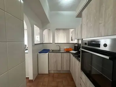 a kitchen with a sink and a stove top oven at White House By FHR in Quarteira
