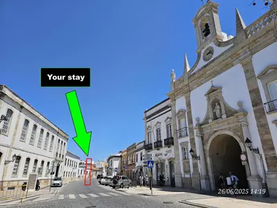 a large building with a green arrow on a street at Blife Castelya private property in Faro