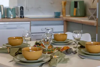 a table with bowls and plates and wine glasses on it at NEW! Dream Terrace Albufeira Ocean and Pool Views in Bicas