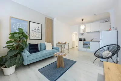 a living room with a couch and a table and chairs at Magna Studio in Albufeira