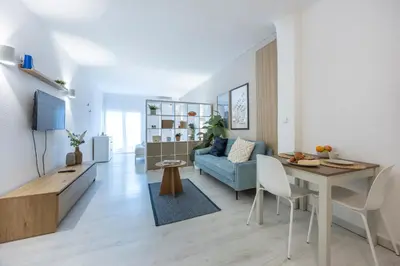 a dining room with a white table and white chairs at Magna Studio in Albufeira