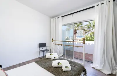 a room with a balcony with a chair and a window at Bmyguest - Vale do Lobo Family Beach Villa in Vale do Lobo