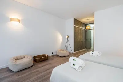 a white room with two beds and a chair at Bmyguest - Vale do Lobo Family Beach Villa in Vale do Lobo