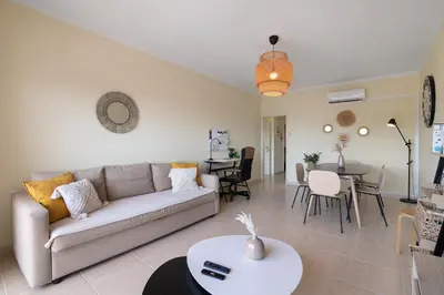 a living room with a couch and a table at Marbel Sol Apartment Al in Quarteira