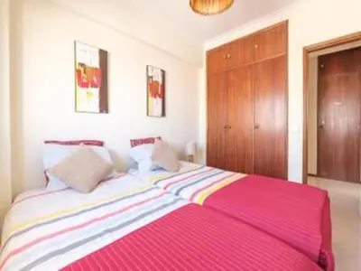 a bedroom with a large bed with a pink blanket at Faro Charm Apartment - City Center in Faro