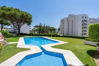 a swimming pool in a yard with a building at HostWise - Sunny Escape with a Pool & Balcony in Vilamoura