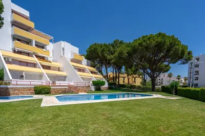 an apartment with a swimming pool in front of a building at HostWise - Sunny Escape with a Pool & Balcony in Vilamoura