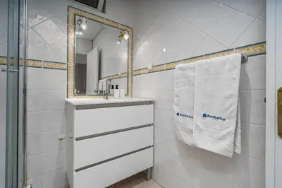 a white bathroom with a sink and a mirror at HostWise - Sunny Escape with a Pool & Balcony in Vilamoura