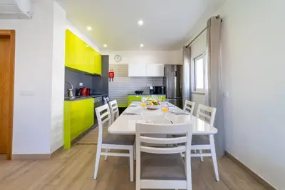 a kitchen and dining room with a white table and chairs at Golden View Villa by HelloVacations in Albufeira
