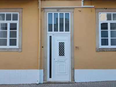 a white door on the side of a building at Simply House in Faro