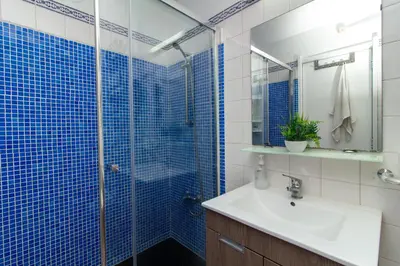 a bathroom with a sink and a shower with blue tiles at Bayview Old Town Beach Apartment in Albufeira