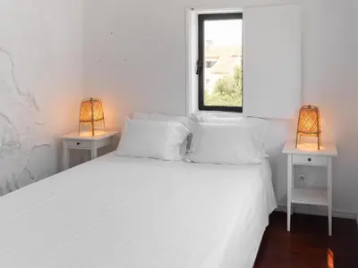 a bedroom with a white bed with two lamps at Delta Marina in Vilamoura