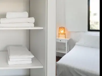 a room with a bed and a shelf with towels at Delta Marina in Vilamoura