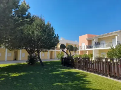 a fence with trees in front of a building at Encosta Sao Jose - Apartment V in Albufeira