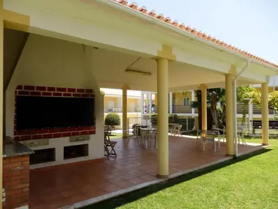 a covered patio with a fireplace and a large screen tv at Encosta Sao Jose - Apartment V in Albufeira