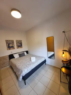 a kitchen with a counter with a microwave and two chairs at Beach Center 2T in Albufeira