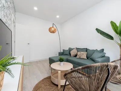 a living room with a green couch and two chairs at Akisol Faro Cobalt in Faro