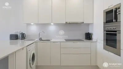 a white kitchen with a sink and a stove at Apartamento Fairway in Loulé