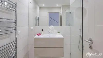 a white bathroom with a sink and a shower at Apartamento Fairway in Loulé
