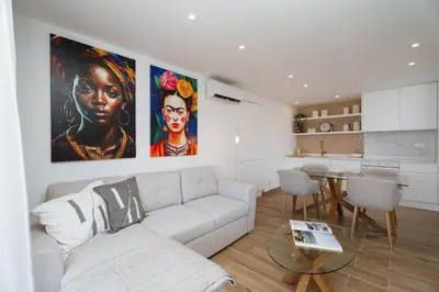 a living room with a white couch and a table at Vilamoura Collection in Quarteira
