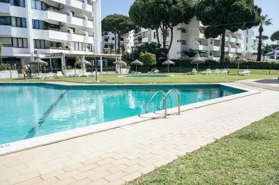 a swimming pool in front of a building at Vilamoura Collection in Quarteira