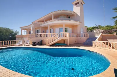 a house with a large swimming pool in front of a house at Quinta da Violeta in Loulé