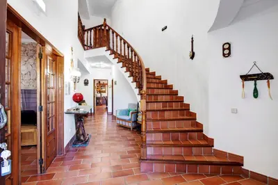 a staircase in a home with white walls and brown tile floors at Quinta da Violeta in Loulé