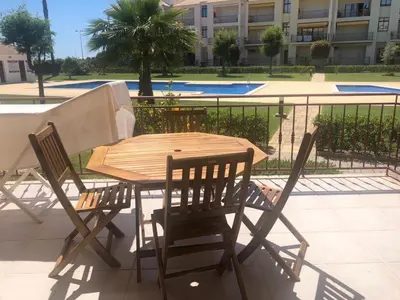 a wooden table and chairs on a patio at Beach Apartment Vilamoura Villa Columbus in Vilamoura