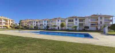 a large apartment building with a swimming pool in front of it at Beach Apartment Vilamoura Villa Columbus in Vilamoura