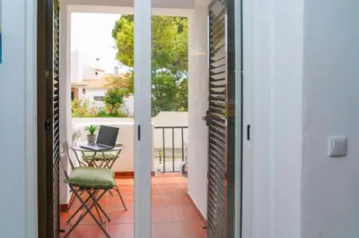 a door leading to a balcony with a table and a laptop at Apartment Maresias 120 m Oura Beach By Bedzy in Albufeira