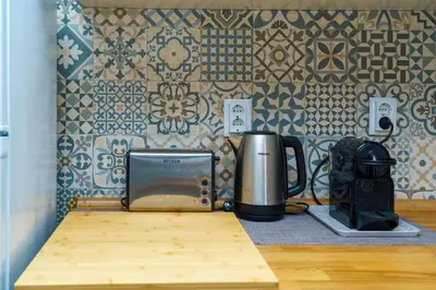a counter with a microwave and a toaster and a coffee maker at Apartment Maresias 120 m Oura Beach By Bedzy in Albufeira