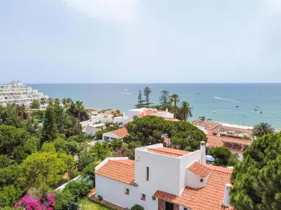 a view of a white house and the ocean at Apartment Maresias 120 m Oura Beach By Bedzy in Albufeira