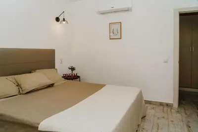 a bedroom with a large bed in a white room at Apartment Maresias 120 m Oura Beach By Bedzy in Albufeira