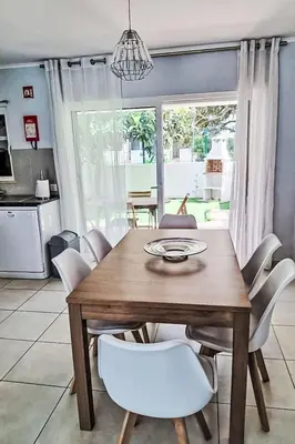 a dining room with a wooden table and white chairs at Holiday Home Villa Medusa by Interhome in Vilamoura