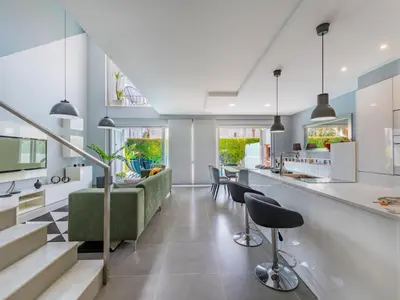 a kitchen and living room with a bar and chairs at Holiday Home Miguel VIP Properties by Interhome in Albufeira