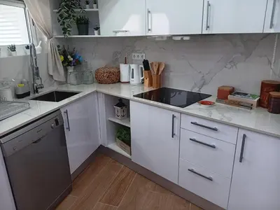 a kitchen with white cabinets and a counter top at Casa Tapada do Bento III- Albufeira in Albufeira